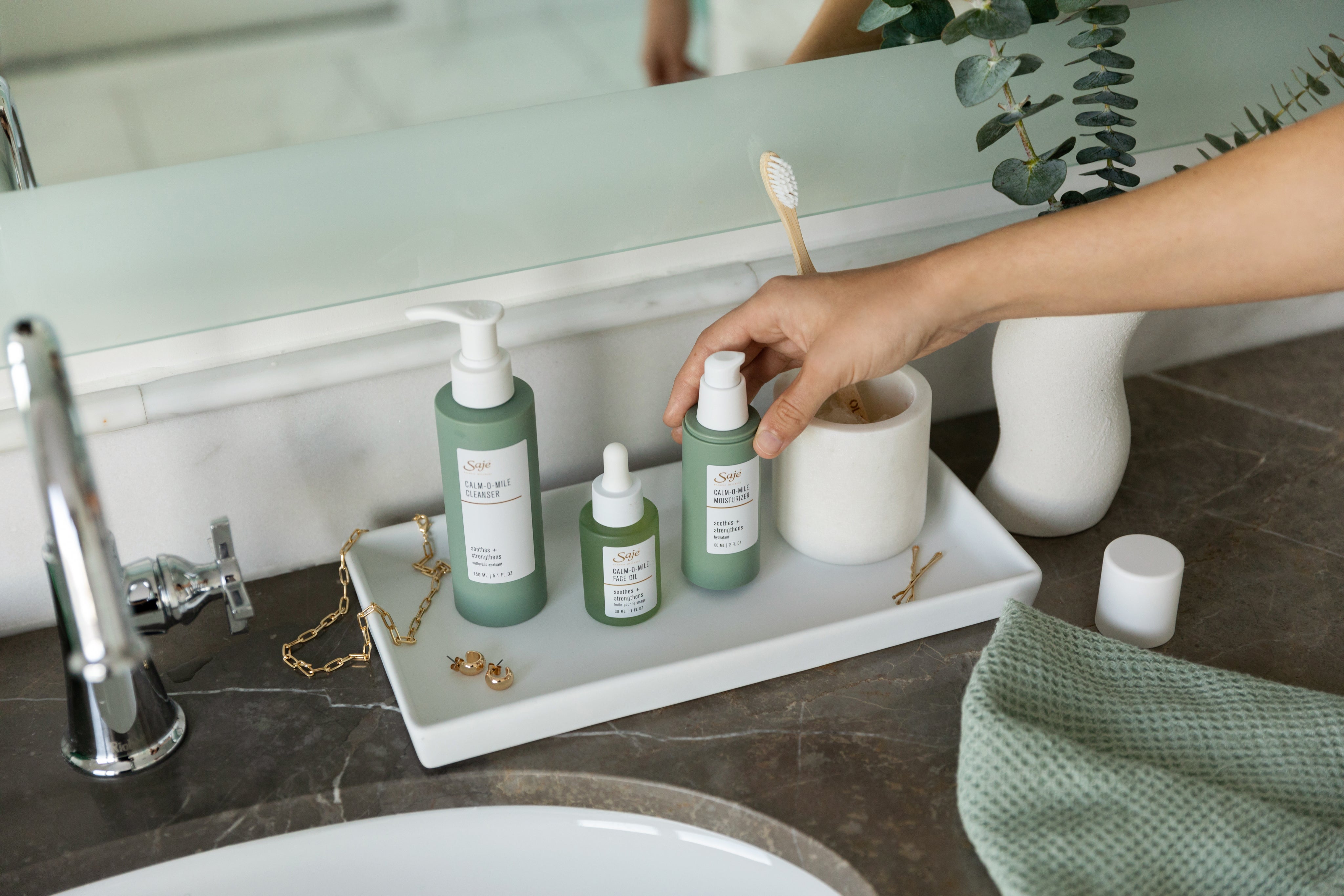 Saje skincare products on a bathroom counter