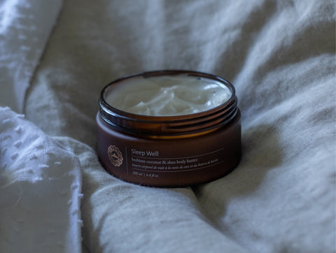 Sleep well body butter placed on a comforter
