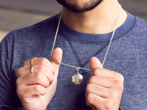 silver men's locket worn by a male model