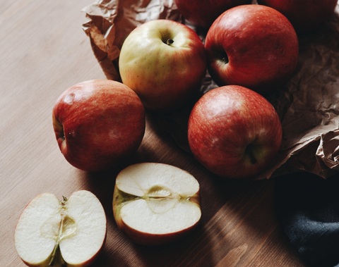 Apples on table, some are halved.