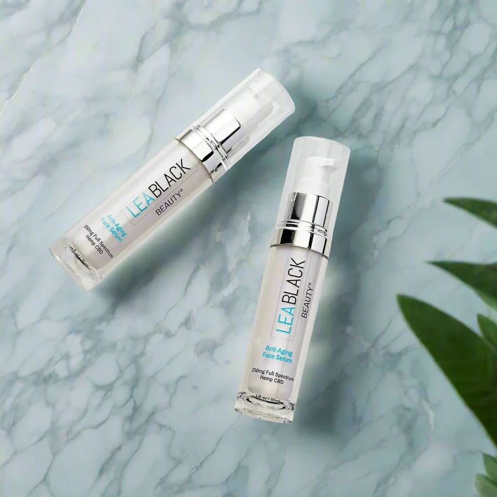 Two Lea Black Beauty® CBD Face Serums on marble surface