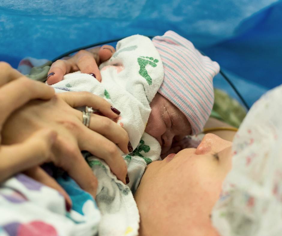 Mother holding her newborn baby after a cesarean delivery