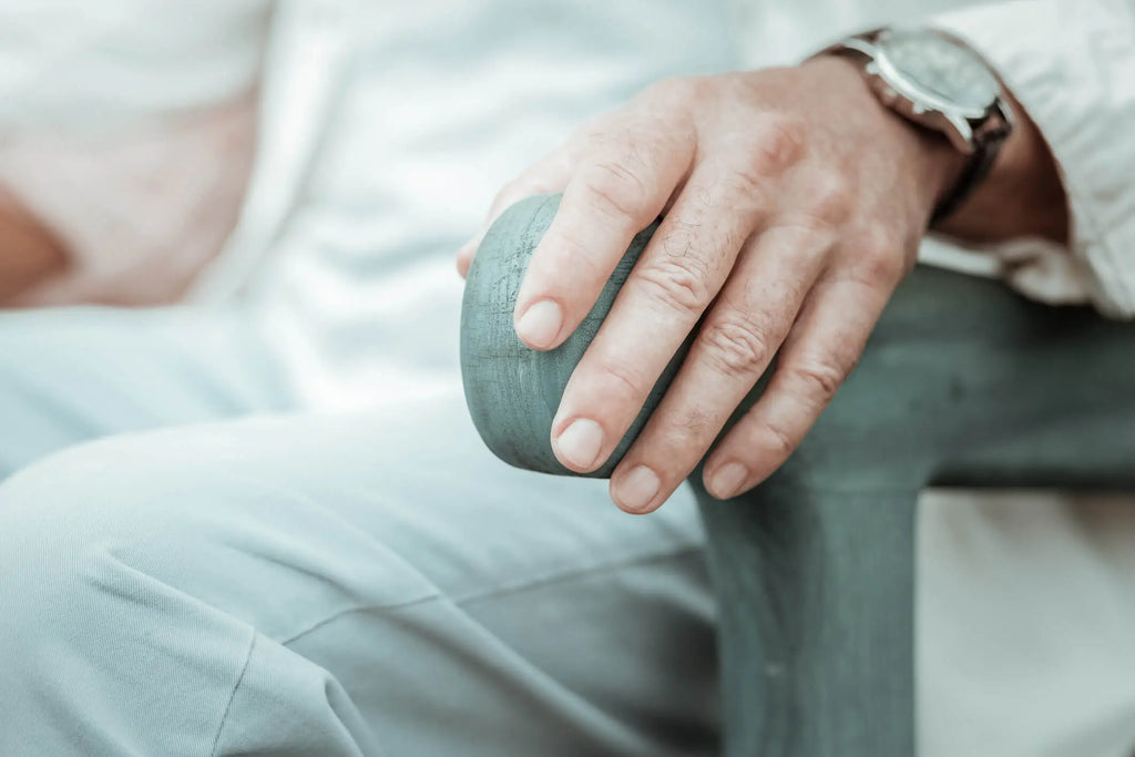 main d'un homme âgée sur le rebord d'une chaise