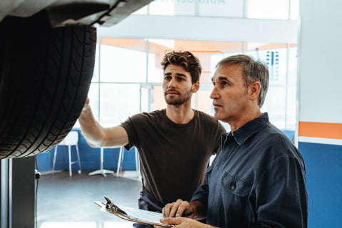 Mechaniker ueberpruefen ein Auto