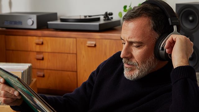 man with headphones listening to turntable