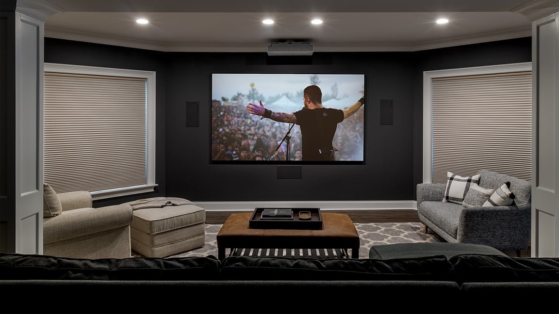 home theater with in-wall speakers, projector, and projector screen and closed Lutron shades