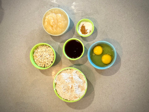 ingredients for applesauce muffins: applesauce, whole wheat flour, eggs, maple syrup, oats