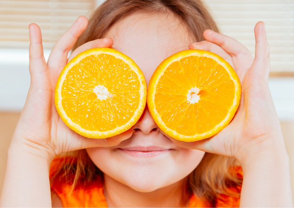 Kid holding up oranges