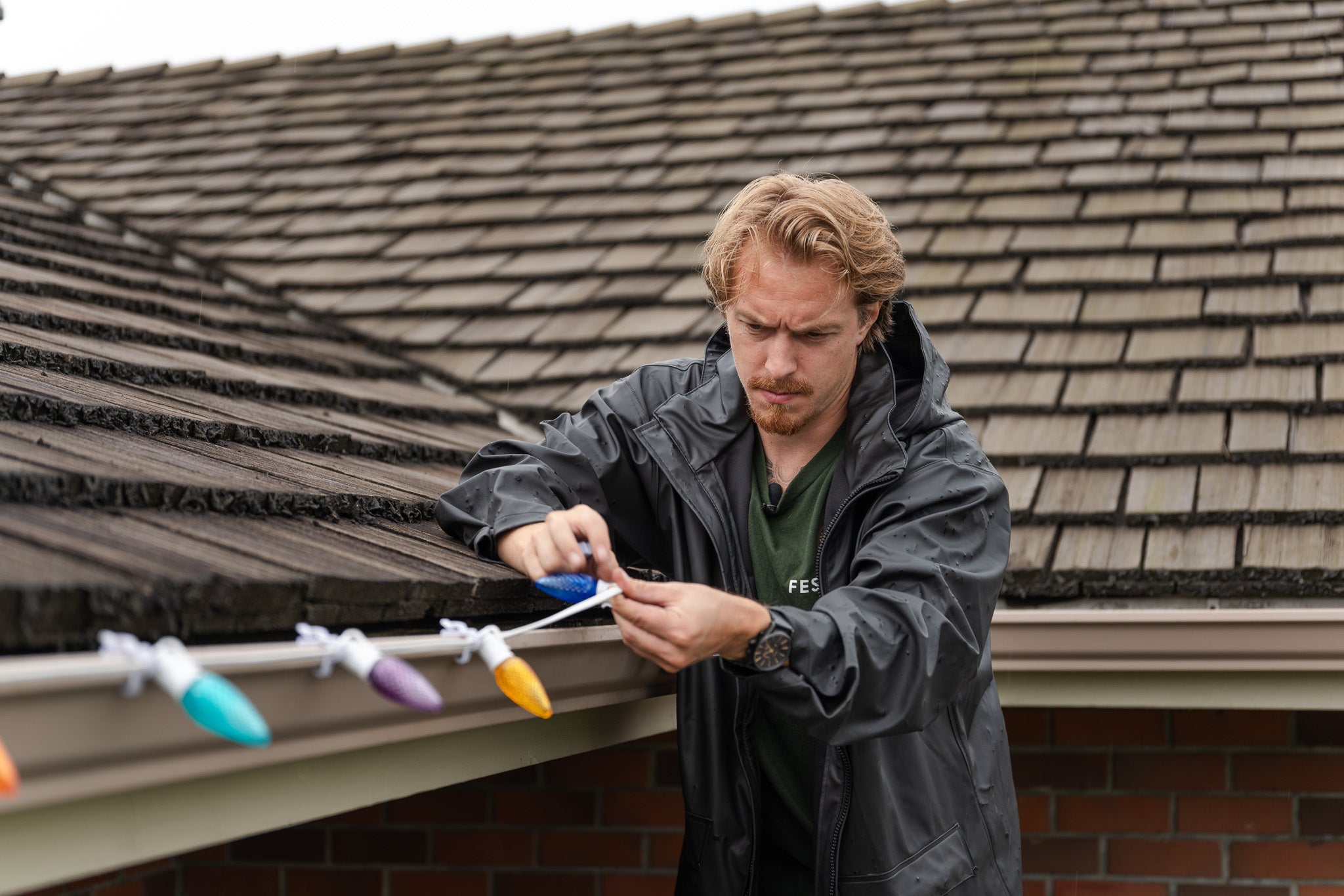 Holiday light installer looking concerned mid installation