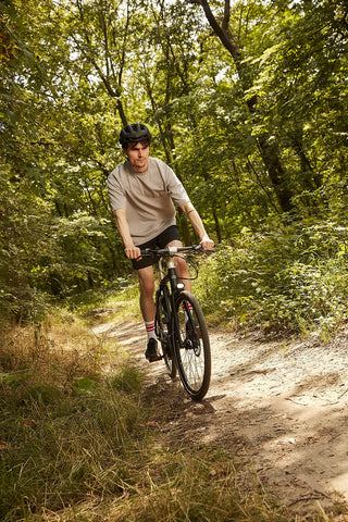 Homme en position sportive en train de faire du vélo bastille dans la forêt sur les chemins