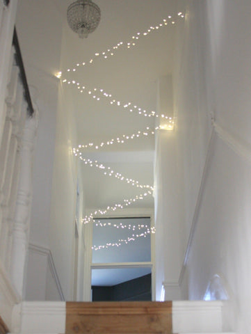 Extra long fairy lights zig zag along white ceiling
