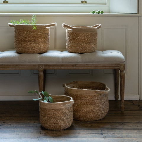 Set of 4 jute baskets on bench with window