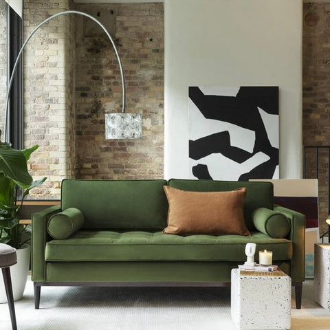 Green Velvet Swyft Sofa with lamp and brick wall