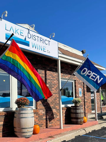 The outside of Lake District Wine Co. with an Open flag and a Pride flag.