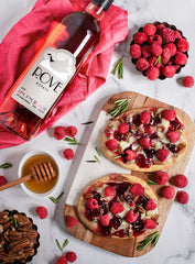 A bottle of Rove's Pinot Noir Rosé with a raspberry brie pizza beside it.