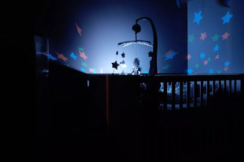 Leuchtendes Mobile im abgedunkelten Kinderzimmer