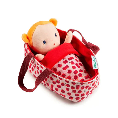 Soft Baby Doll with blond hair in red cot and blanket with white dots.
