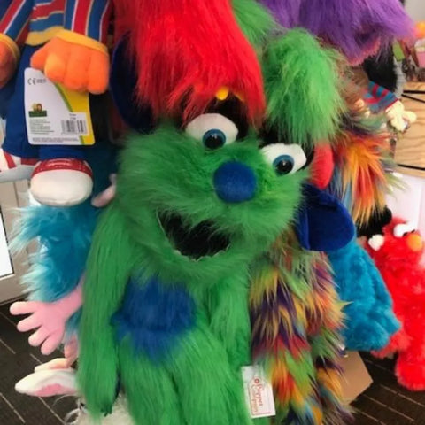 Green Monster Hand Puppet on a stand with other colourful puppets.