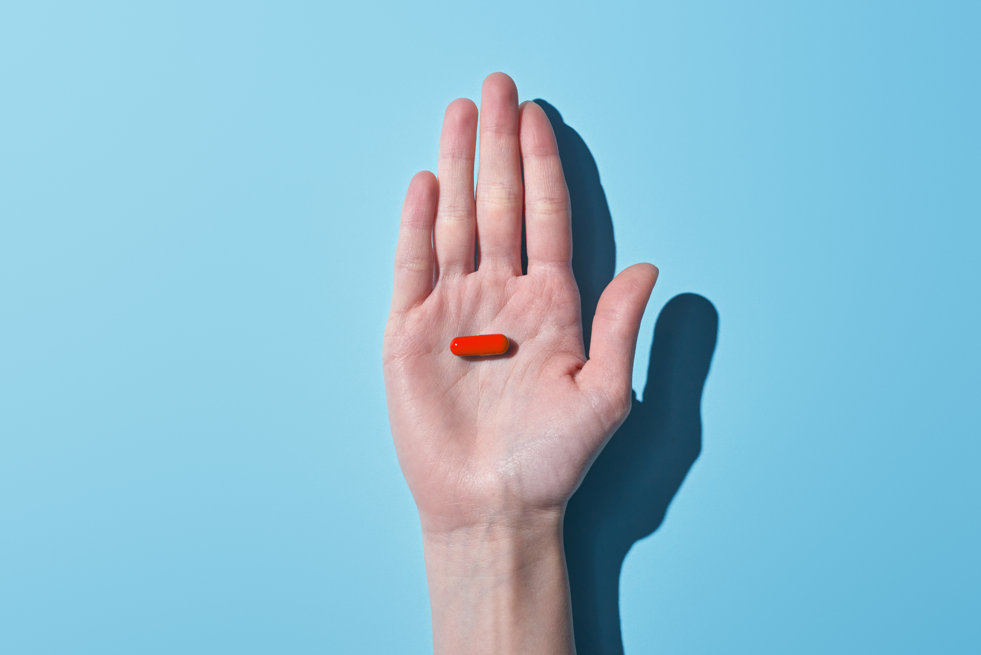 A hand holding the LIFEHACKR Productivity Pill