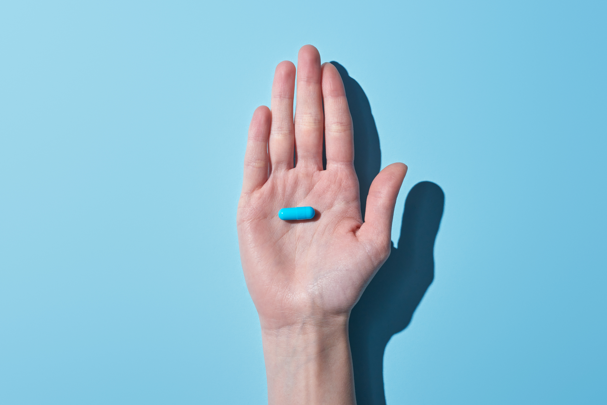 A hand holding the LIFEHACKR Recovery Pill