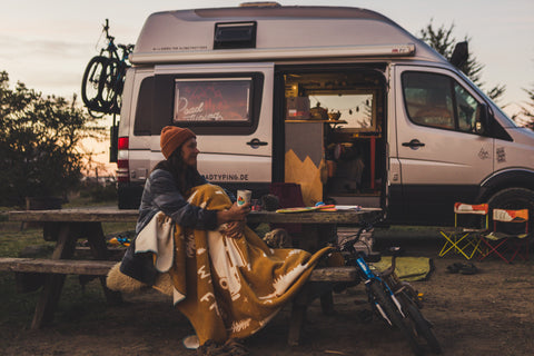 Kuscheldecke Camping Grundausstattung vor dem Campervan Abend vor dem Wohnmobil