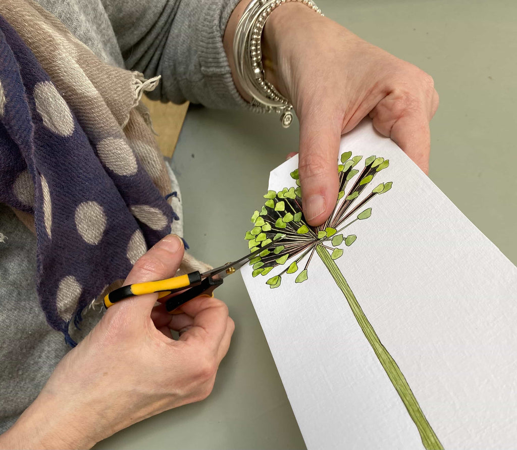 Close-up photo of artist cutting out flowers.