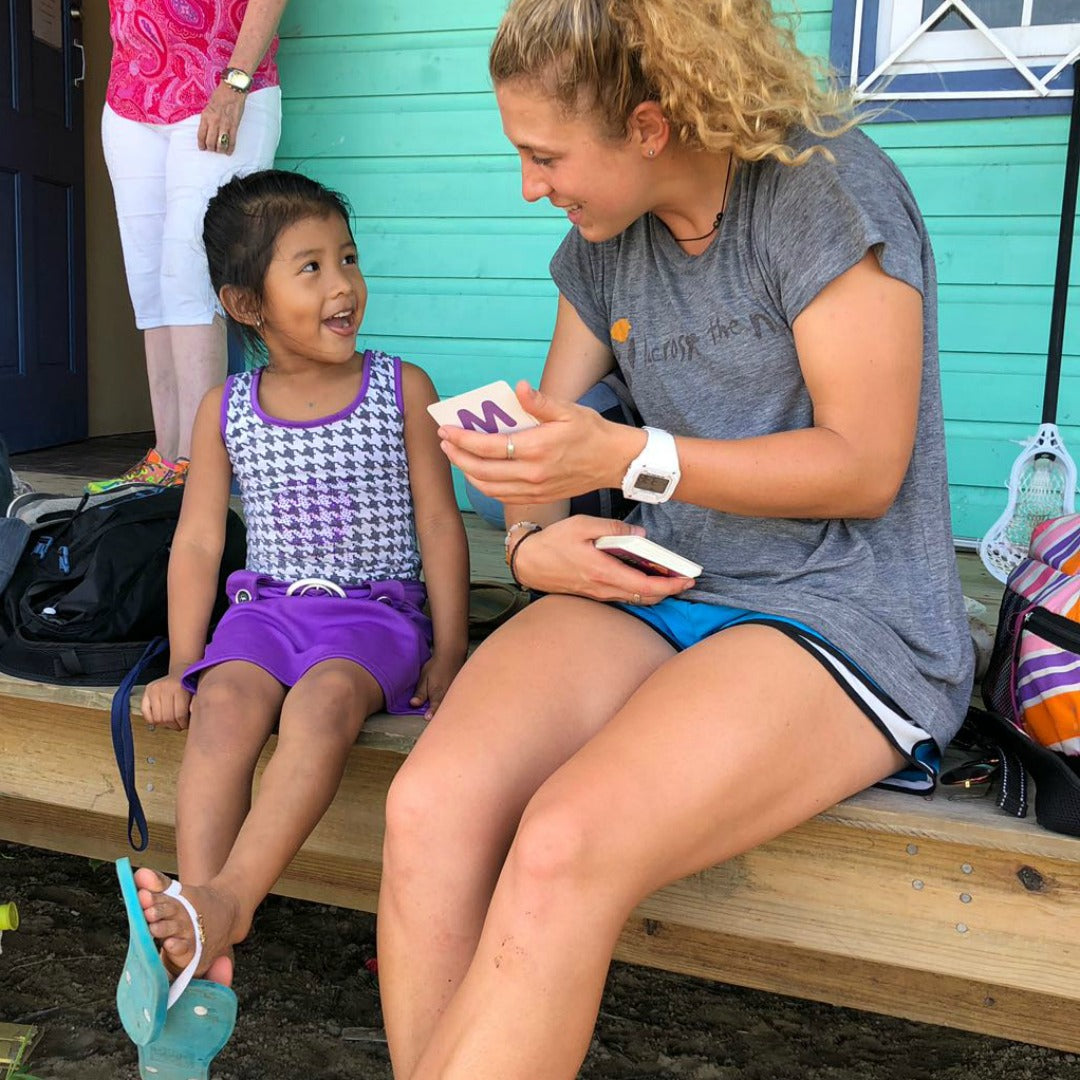 Coach Brooke Wilson talking to young girl - Lacrosse the Nations