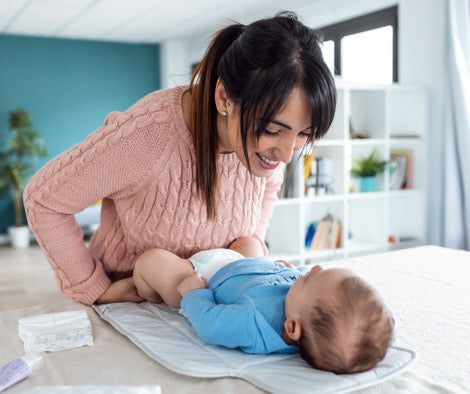 Mother playing with baby on change table