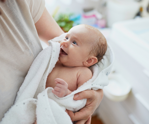 Baby wrapped in a towel in parents arms