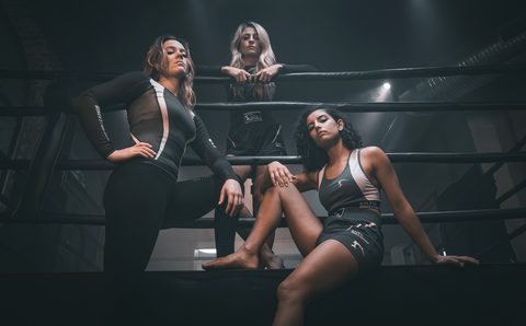 Femmes qui font du sport de combat pour femmes dans un ring noir