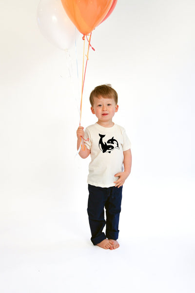 Young boy wearing a Orca tee shirt and holding a yellow balloon