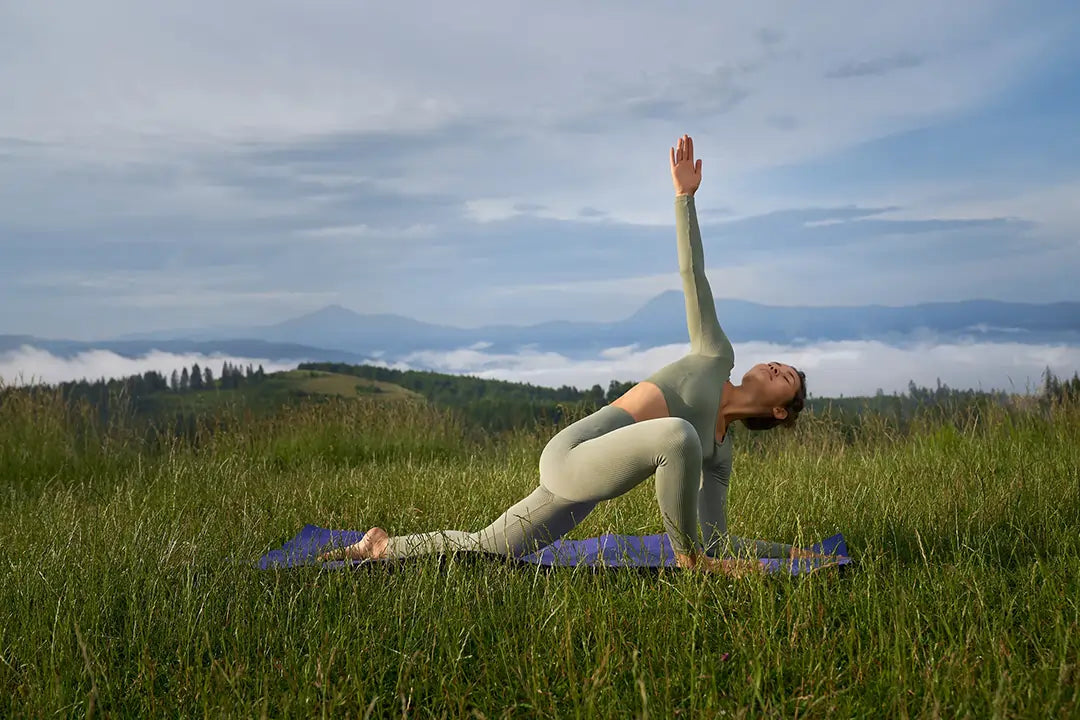 mujer-practicando-yoga-en-la-naturaleza-para-mejorar-colesterol-y-salud-cardiovascular