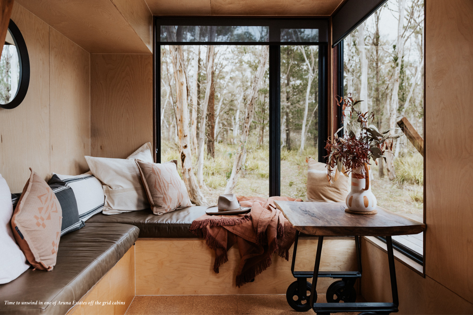 Lounge bench with scatter cushions and view of bush in one of Aruna Estates off grid cabins