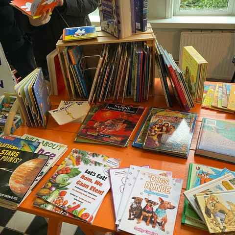 A variety of children's books placed on an orange table.