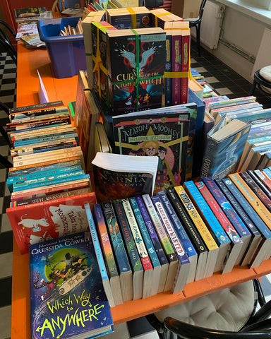 Table piled with middle grade fiction books.