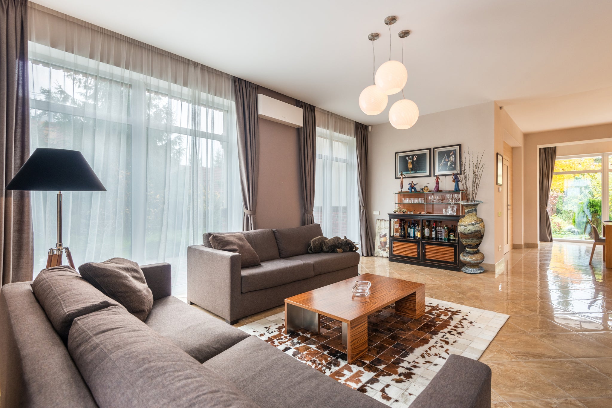 A living room with a neutral colour theme, with two couches, a coffee table, a cabinet, and beside the cabinet is the Authentic Jade Vase.