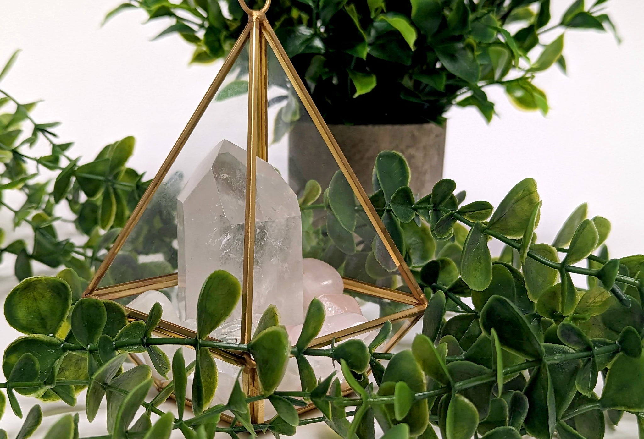 Crystal tower in a glass terrarium, surrounded by plants