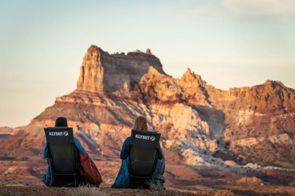 people sitting in camping chairs enjoying canyon view