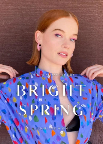 Woman wearing a colorful shirt with abstract patterns and text 'BRIGHT SPRING' and 'BRIGHT AND WARM'