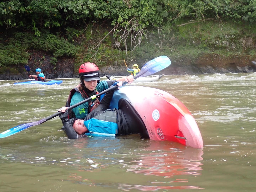 Paddler learning how to roll whitewater kayak