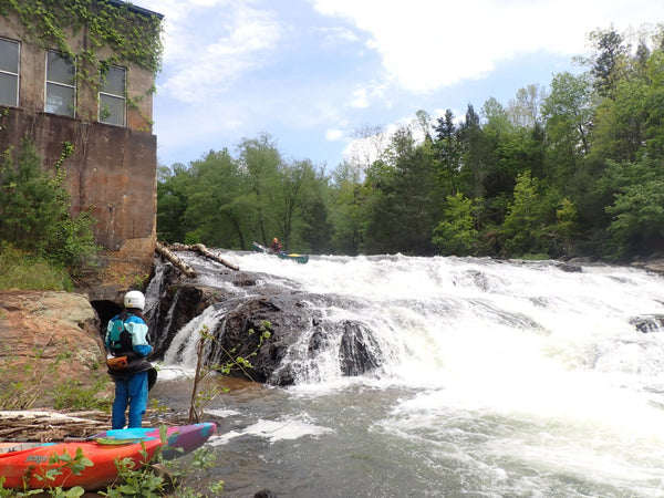 Kayaker scouting a section of falls and rapids