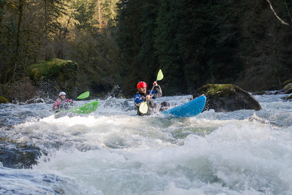 two kayakers taking on a whitewater rapid