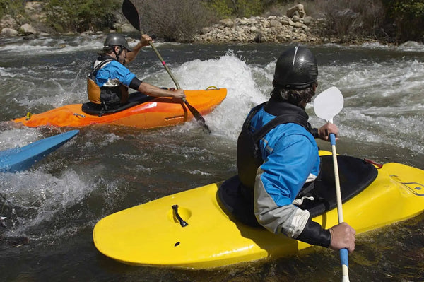 two kayakers taking on a whitewater rapid