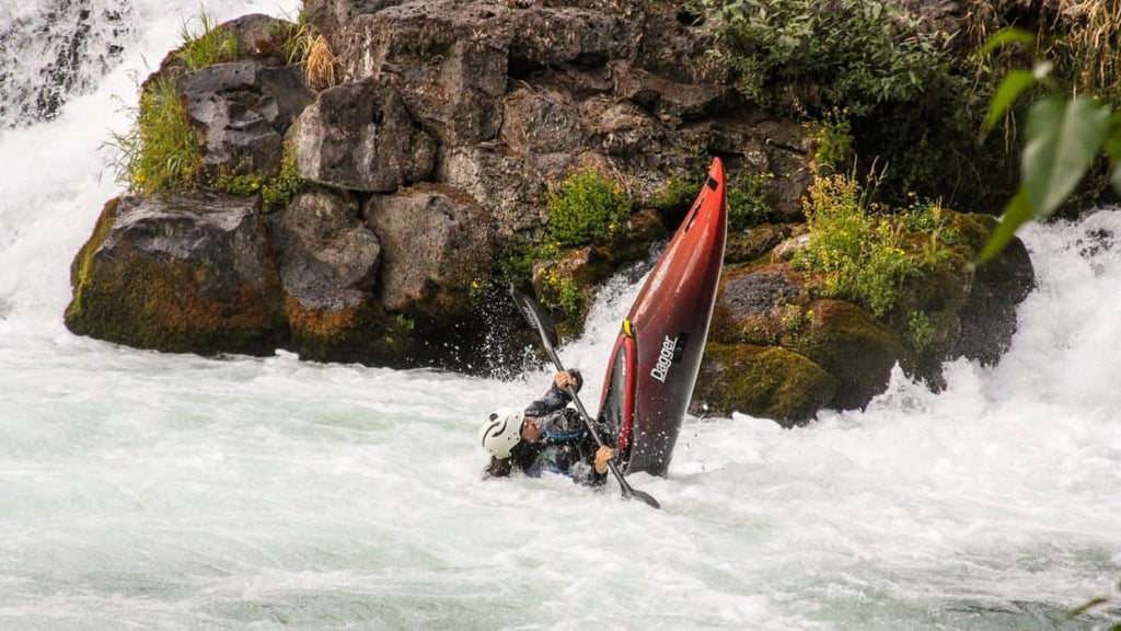whitewater kayaker doing a stern squirt