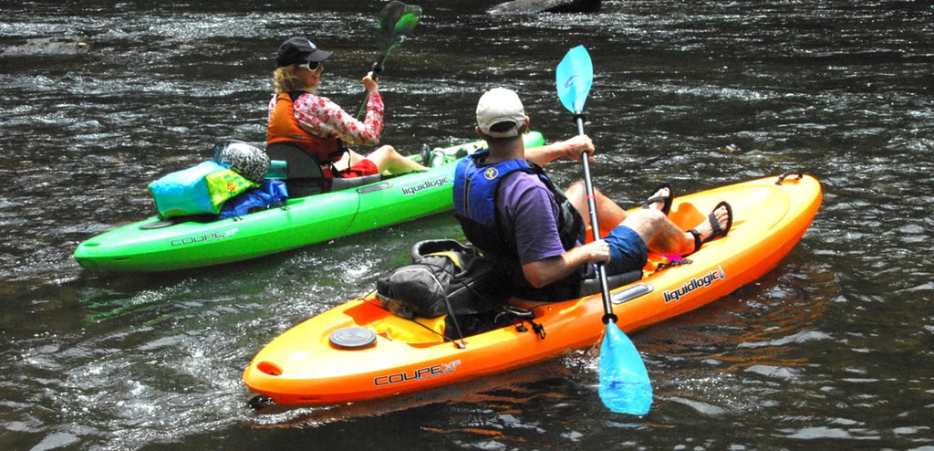 Two kayakers paddling, wearing life jackets