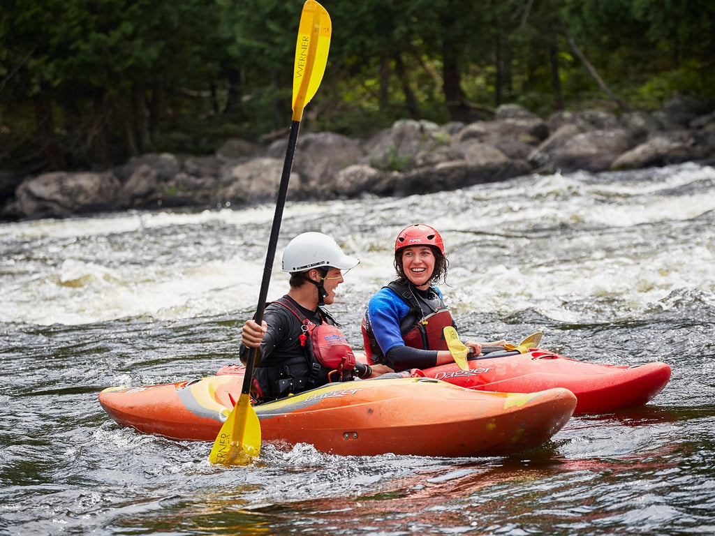 Kayak instructor and beginner in kayaks on water