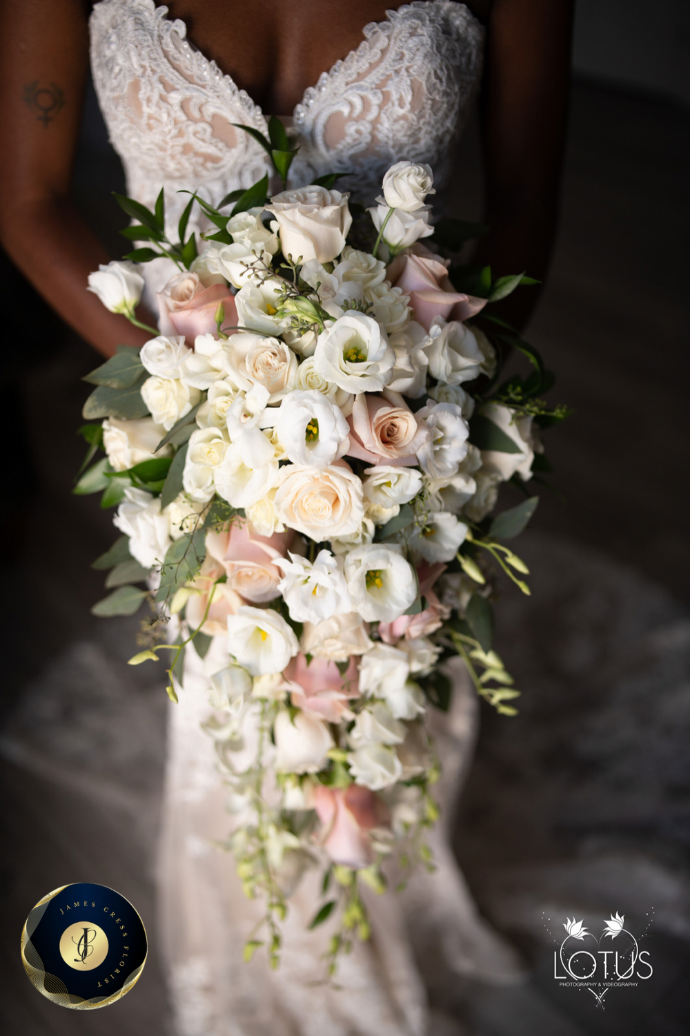 Image of wedding flowers, a new bride in a beautiful dress is holding her stunning white bridal bouquet.