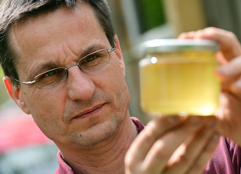 Christian Grune hält ein Honigglas von Honigtreu in der Hand