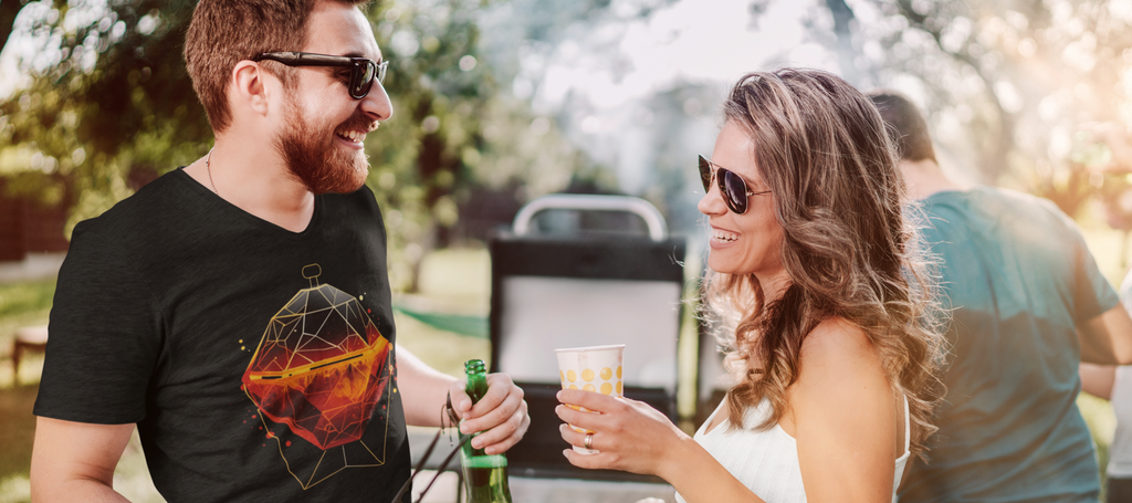 Ein Mann in einem Wildspark Premium Organic Shirt steht mit einer Frau am Grill und lacht