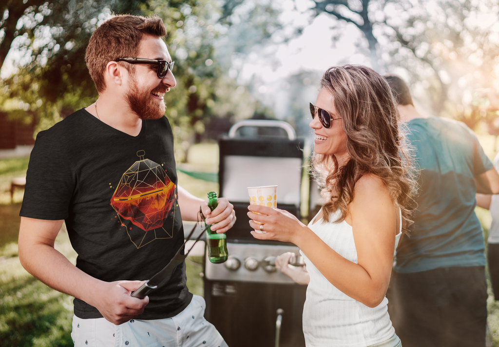 Ein Mann und eine Frau die vor einem Grill stehen und sich gut amüsieren. Der Mann trägt ein Wildspark Spark Sphere Shirt.